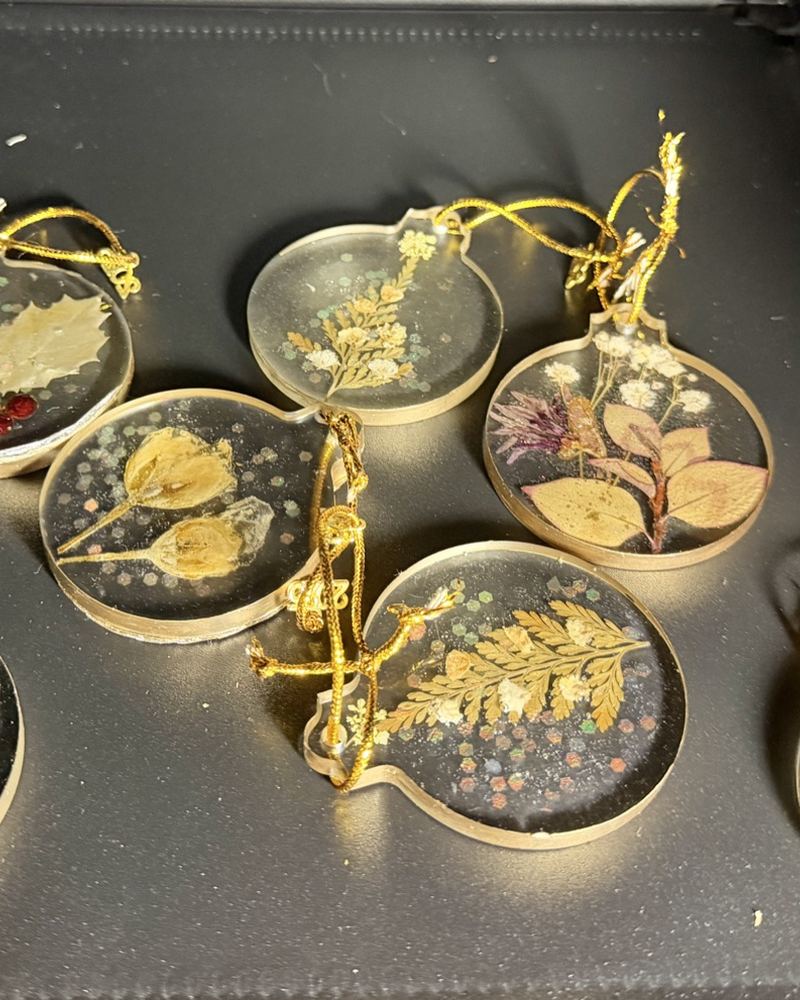 Round resin Christmas ornaments with dried flowers and ferns, gold rims and gold hanging cords